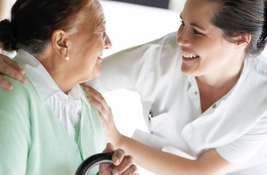 Happy young nurse with an old patient